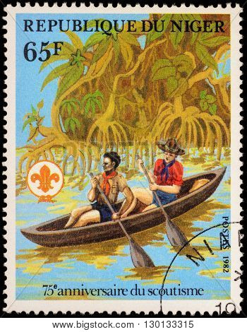 MOSCOW RUSSIA - MAY 14 2016: A stamp printed in Niger shows two boyscout in canoe on the river among mangroves series 