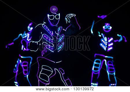 Dancers Crew In Led Suits On Dark Background, Colored Show