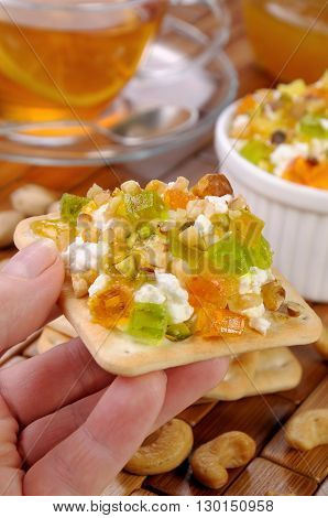 portion of cottage cheese with jam and marmalade nuts on a cracker