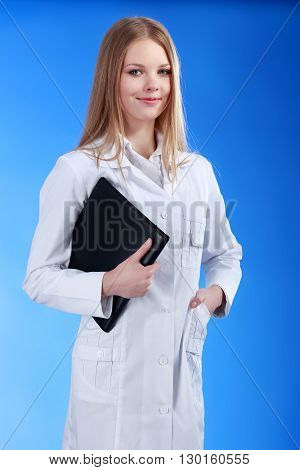 Young attractive doctor isolated over blue background