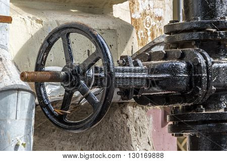 Photo with brutal black valve on the wall of the house