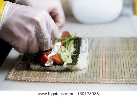 closeup of chef preparing sushi in the kitchen shallow DOF