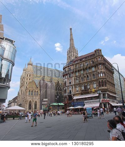 VIENNA AUSTRIA - JULY 12; Stephansplatz square with St. Stephen cathedral and tourists walking around in Vienna Austria - July 12 2015: Famous historical landmark St. Stephen cathedral during sunny summer day with people walking around
