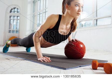 Beautiful young slim woman doing some gymnastics at the gym with medball