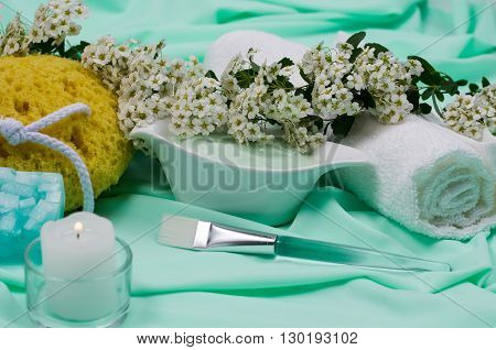 Close-up. Spa Still Life. At the Turquoise Fabrics. Burning Candle. Sponge. Natural flowers. Towel. Handmade Soap.