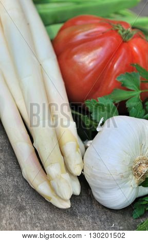 white asparagus garlic parsley and tomato on wooden background
