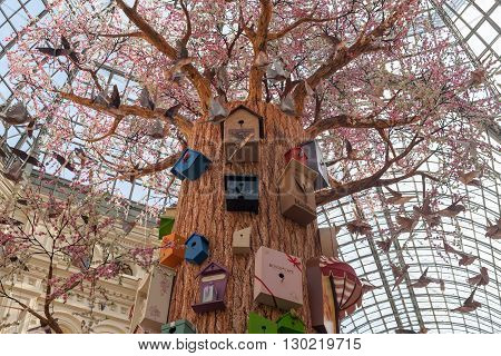 MOSCOW - APRIL 13: Artificial tree birds and birdhouses at GUM store on April 13 2016 in Moscow. GUM is the large store in the Kitai-gorod part of Moscow facing Red Square.