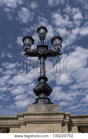 Bordeaux lamppost in black iron against blue sky