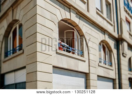 Tilt-shift photo of woman reading in her apartment iwth beautiful large windows on a warm spring day