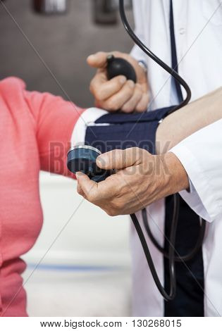 Cropped Image Of Doctor Checking Blood Pressure Of Senior Patien