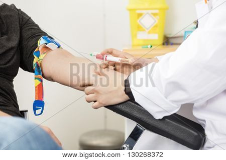 Cropped Image Of Doctor Collecting Blood From Patient