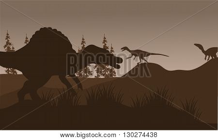 Silhouete of spinosaurus and eoraptor in hills with brown backgrounds