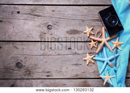 Marine items and old camera on weathered wooden background. Sea objects on wooden planks. Selective focus. Flat lay. Vacation background.