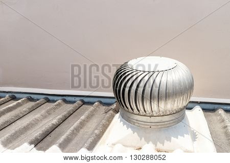 Silver spinning roof ventilator on roof house