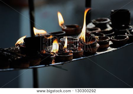 Burning candle row in a hindu temple Orissa India