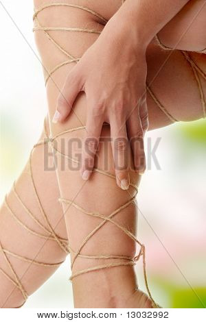 Concepto de dolor de piernas - piernas atadas con cuerda