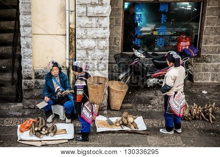 YUANYANG, CHINA - FEBRUARY 28,2016: Chinese Hani farmers sell their goods on the market,The Hani or Ho people are an ethnic group of Southeast Asia