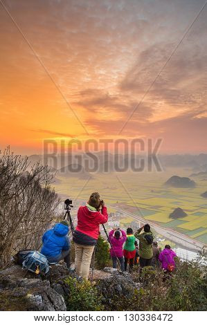 YUNNAN,CHINA-FEBRUARY 26,2016 :Tourist taking a picture for sunrise on the rock view from Luoping,Yunnan,China