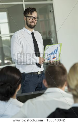 Young successful business man presenting the results of the latest project he has been workng on
