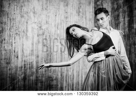 Beautiful young couple in love dancing tango with passion. Professional dancers. Latino dancers. Toned photo, sepia. Retro style.