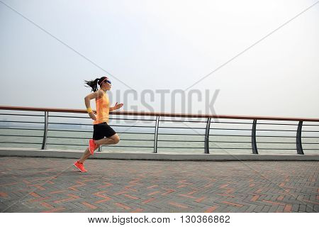 one asian woman runner running on seaside