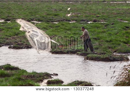 SONGKHLA, THAILAND- MAY 06,2016:Unknown traditional Fishermen who throw the fishing nets at river in Songkhla,Thailand.