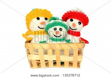 Knitted toys in a wicker basket on a white background