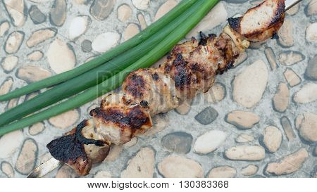 shish kebab on skewers on a stone table with a bow