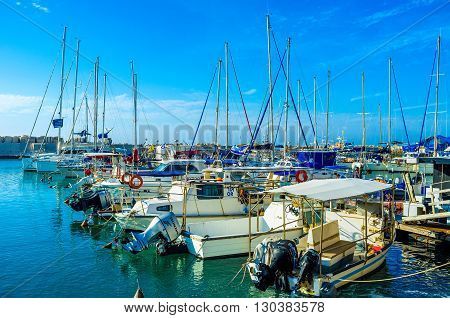 TEL AVIV ISRAEL - FEBBRUARY 25 2016: The old port of Jaffa is the crowded place where tourists enjoy the views choose the boat for fishing and try the local seafood on February 25 in Tel Aviv.
