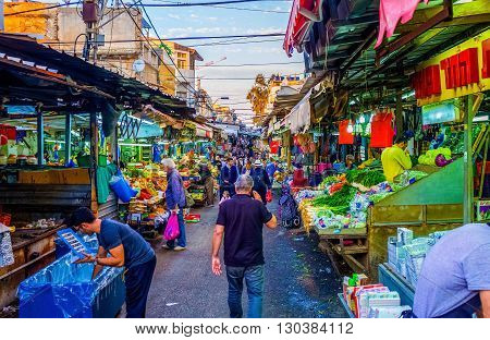 TEL AVIV ISRAEL - FEBBRUARY 25 2016: The noisy and crowded Carmel Market in Yemenite quarter is one of the city landmarks offering fresh vegetables fruits and local food on February 25 in Tel Aviv.