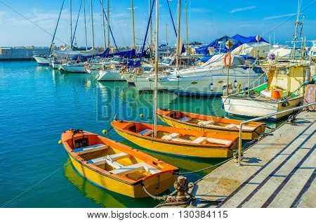 The orange tourist boats moored in old port of Jaffa Tel Aviv Israel.