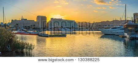 The colorful sunset sky over the Lagoona of Eilat reflects in calm water Israel.