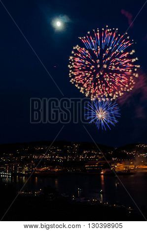 Show of fireworks at the finish of the celebration of the National Day of acceptance on the anniversary of the Norwegian Constitution - May, 17, 2016, Tonsberg, Norway
Can see on picture city by night with port on the Oslofjord port with buildings port.
