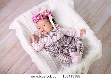 1 month baby girl lies on back looking up and smiling