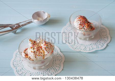 Vanilla ice cream in bowls sprinkled with chocolate and multicolored srpinkles