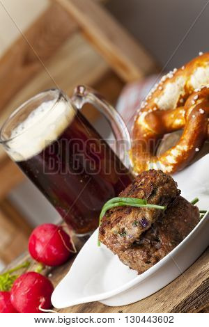 bavarian meatballs with pretzel and beer on a table