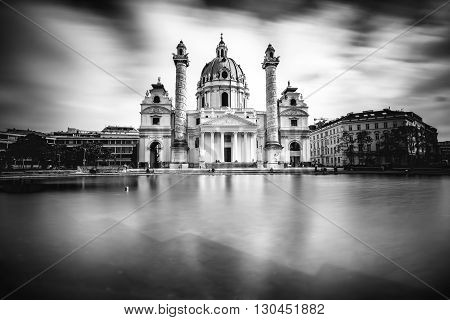 View on st. Charles's church on Karlsplatz in Vienna. White and black image with long exposure technic with blurred clouds and glossy water.