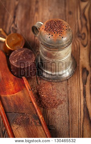 vintage sifter with grated chocolate and  100% chocolate block