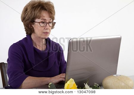 成熟的女人，在笔记本电脑上工作