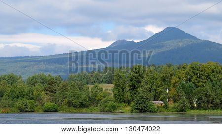 The top of the mountain in the summer at the foot of the mixed forest