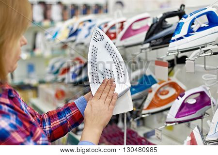 Woman shopping for iron in store close-up