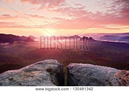 View Over Sandstone Cliff Into Deep Misty Valley In Saxony Switzerland. Sandstone Peaks Increased Fr