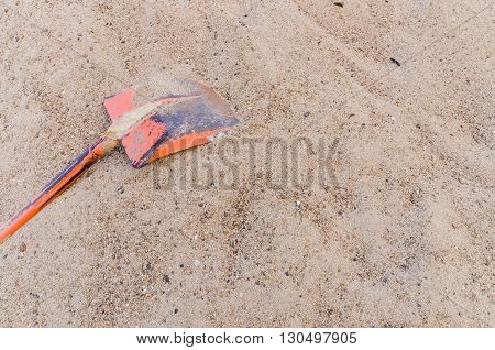 The old orange shovel in sand pile at construction site