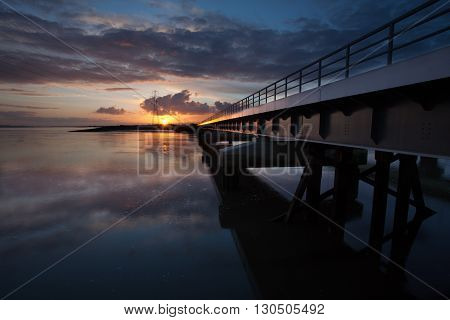 Sunset over the railway bridge going from Swansea to Llanelli crossing over the Loughor estuary, South Wales.