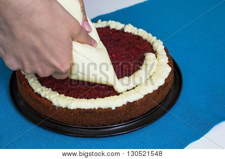 Creamy vanilla frosting being swirled onto sponge cake with professional pastry tip