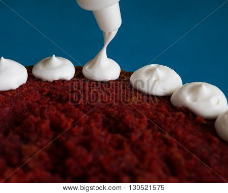 Creamy vanilla frosting being swirled onto sponge cake with professional pastry tip