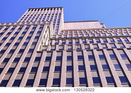 Perspective shot of tall  brick building against blue sky