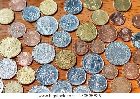Different country coins on a wooden background
