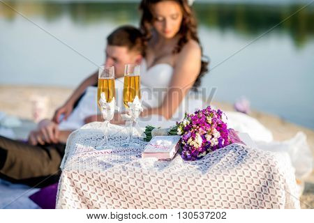 Wedding glasses of white wine on the background of the bride on the lake