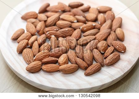 Some almonds in a wooden bowl closeup